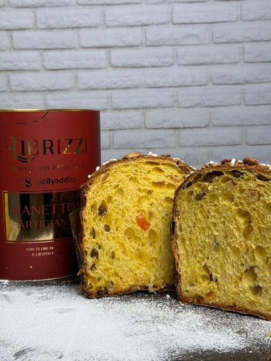 Panettone tradizionale Librizzi Deluxe di SicilyAddict, tagliato con confezione davanti a una parete bianca