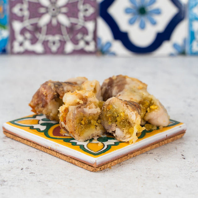 Braciole al pistacchio con ripieno visibile su un piatto decorato