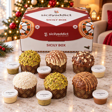 Box di 6 panettoncini assortiti con panettoncini e vasetti di crema disposti davanti alla scatola.