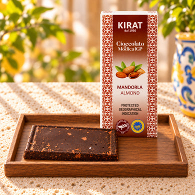 Cioccolato di Modica IGP Kirat alla mandorla, tavoletta coricata sul vassoio e confezione da 100 g in piedi