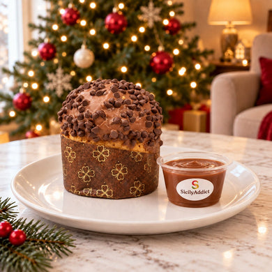 Panettoncino al cioccolato al latte intero su un piatto, con decorazioni natalizie sullo sfondo.