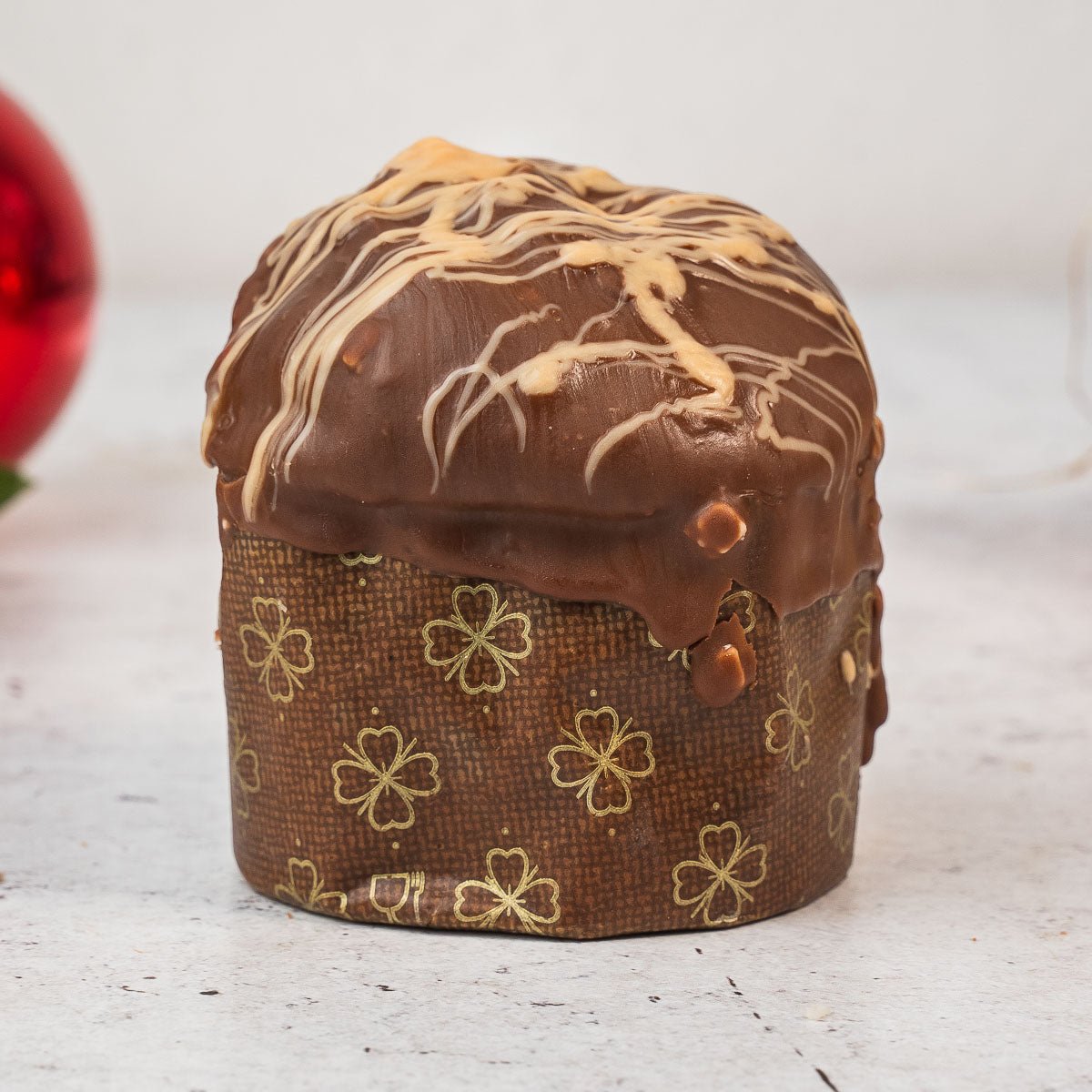 Panettoncino ciokocaramel intero, fotografato su fondo neutro.