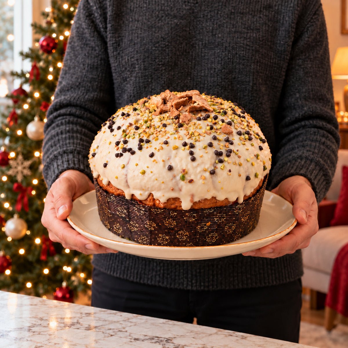 Panettone al cannolo siciliano tenuto in mano davanti alla tavola natalizia.