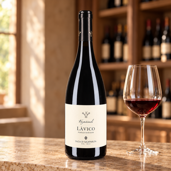 Làvico con calice da degustazione nell’ambientazione calda di un’enoteca.